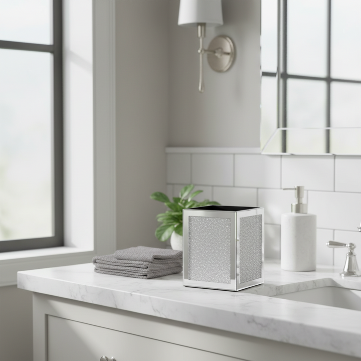 Bathroom counter with a trash can, towels, and soap dispenser.