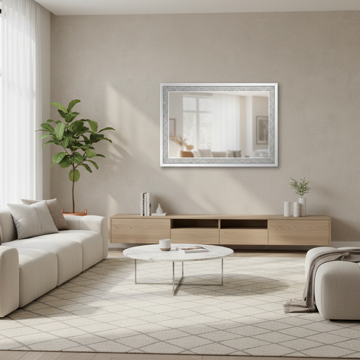 Modern living room with beige walls, a white sofa, wooden TV stand, and decorative mirror.